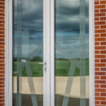 white all glass french entrance door with customized letter sandblasted on each door