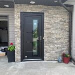 black custom high -efficiency entrance door about 1/4 of the panel is glass on the right side and on the left side four horizontal sections are are also made of glass