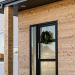 black custom door featuring three horizontal glass panels and one glass sidelight
